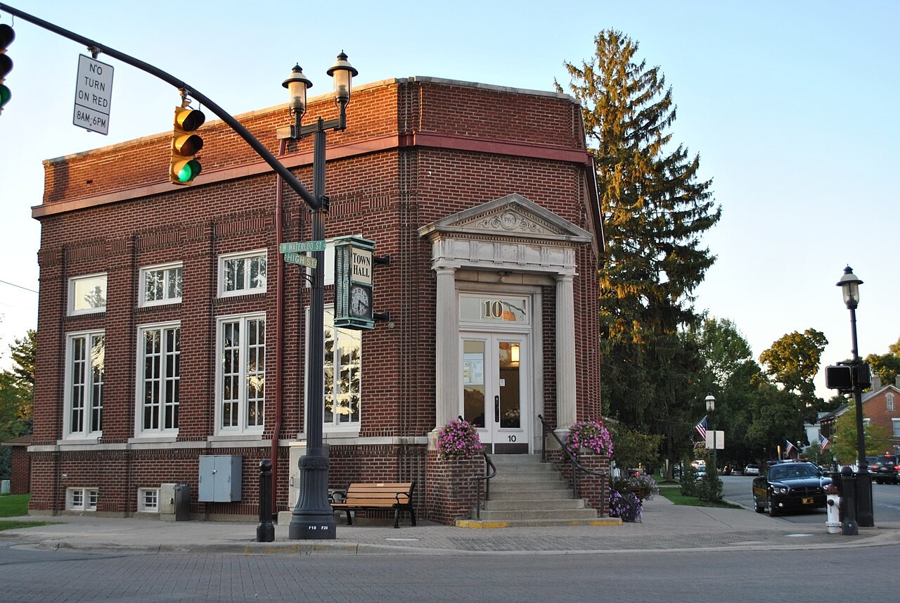 Street corner view showing street signs for West Waterloo Street and North High Street in front of the historic brick Town Hall and Peoples Bank building in Canal Winchester.