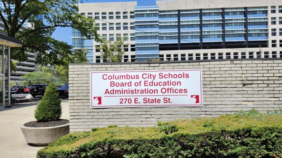 A white sign with red lettering on a brick wall reading Columbus City Schools Board of Education Administration Offices 270 E. State St.