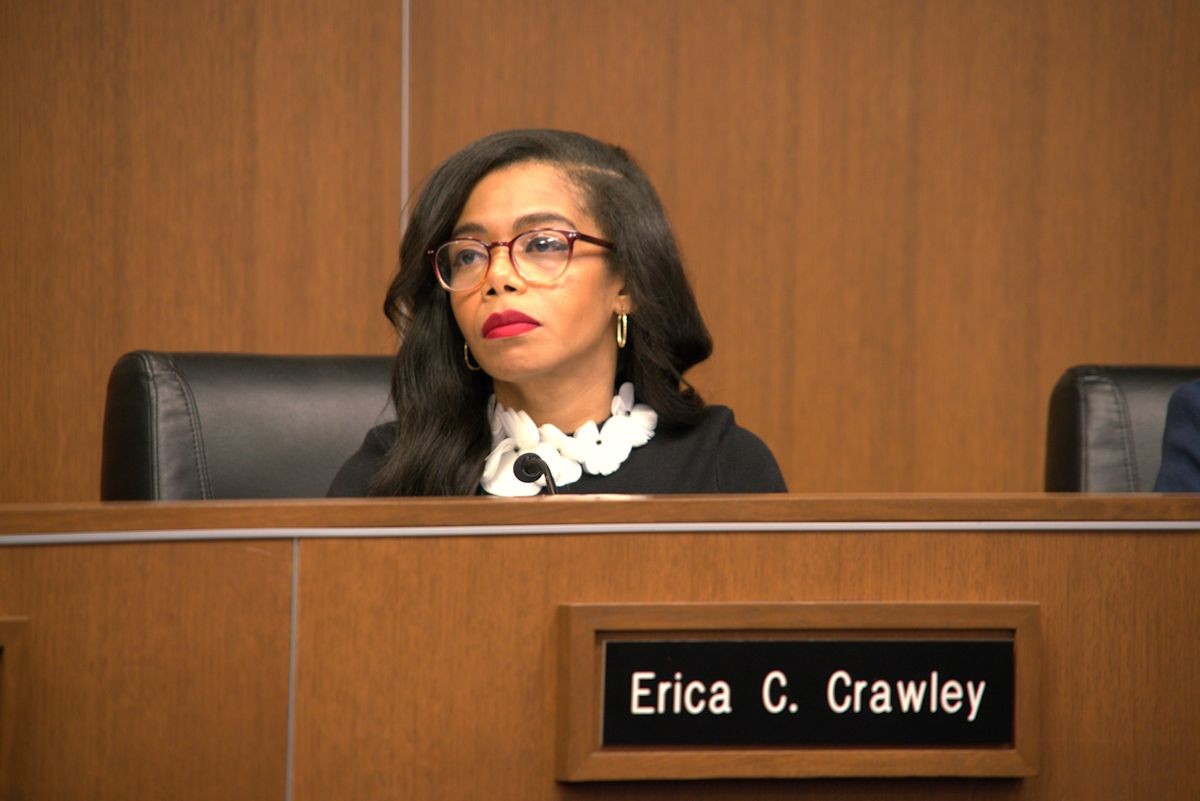 Franklin County Commissioner Erica Crawley seated at a wooden hearing dais behind a nameplate reading Erica C. Crawley.
