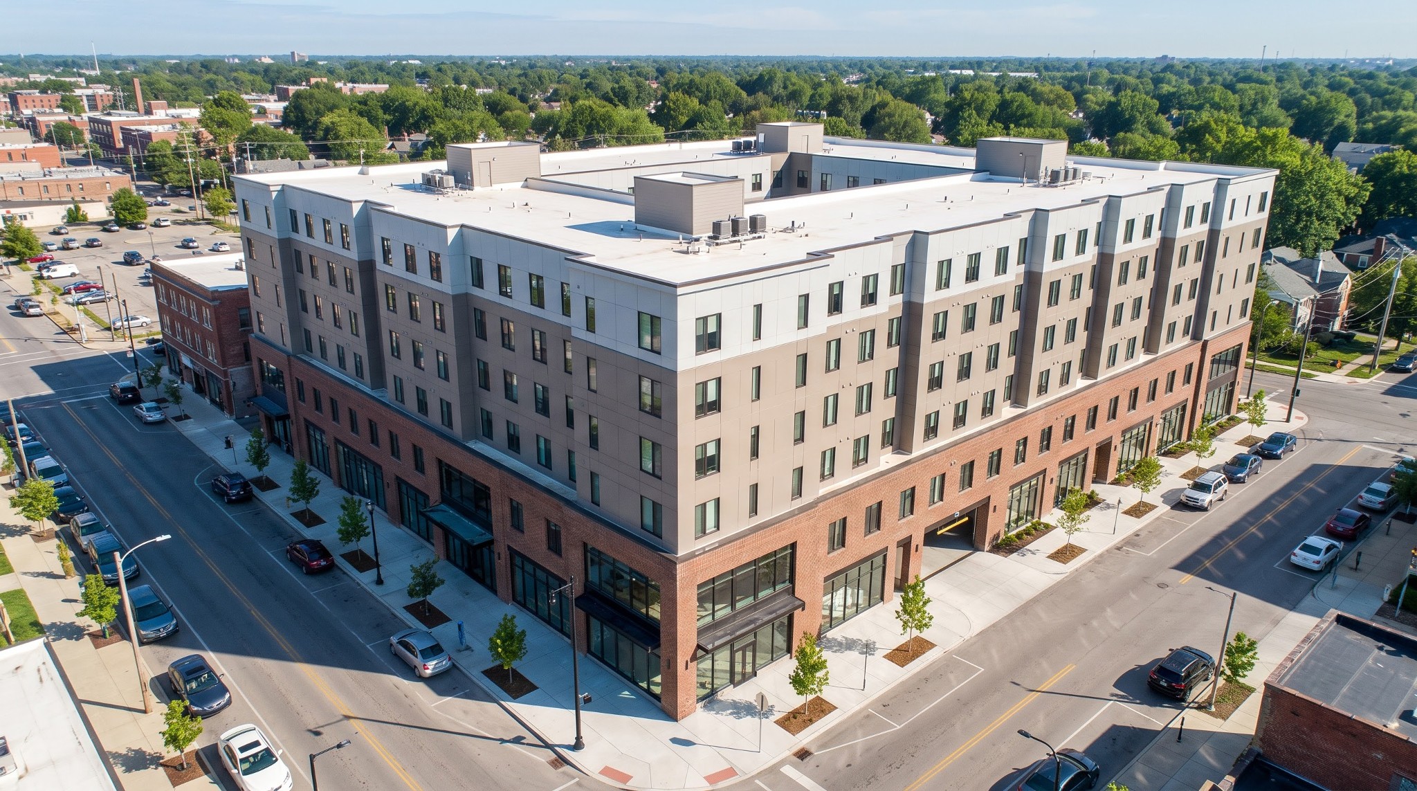 Aerial view of modern 7-story mixed-use building at the corner of North High Street and East Woodruff Avenue in Columbus, Ohio.