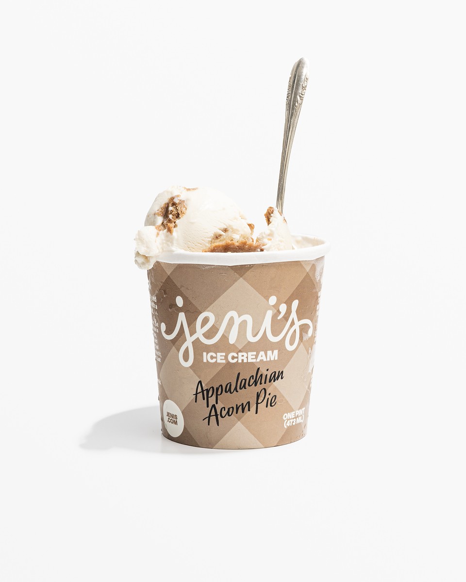 An open pint of Jeni's Appalachian Acorn Pie ice cream with a silver spoon resting in the scoop.