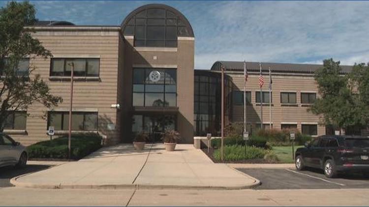 Exterior view of the Ohio Bureau of Criminal Investigation facility with brick facade, arched glass entrance, and flagpoles.