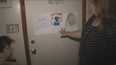 Family members of Rachel Prince displaying pencil drawings and art memorializing her.