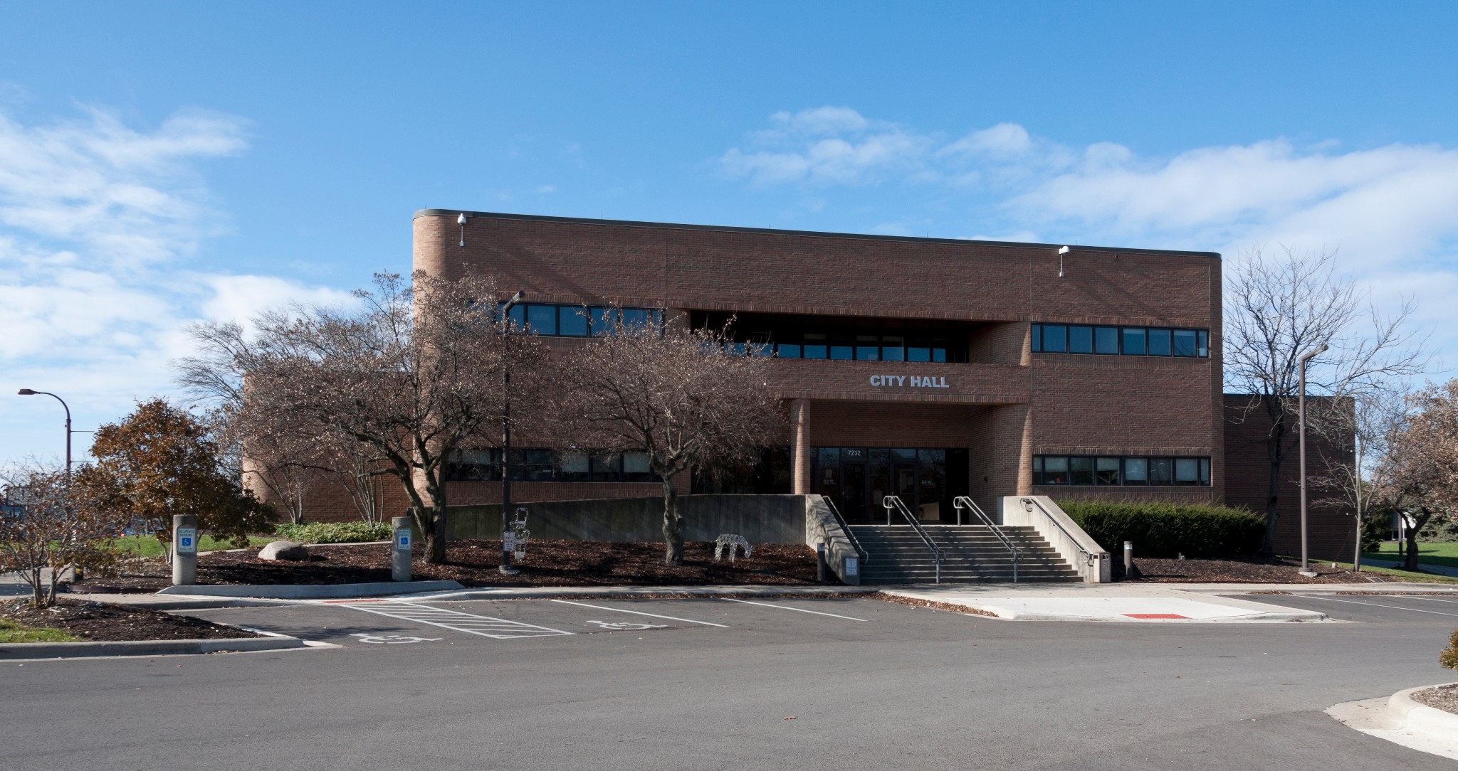 Exterior view of Reynoldsburg City Hall, a two-story brown brick municipal building at 7232 East Main Street.