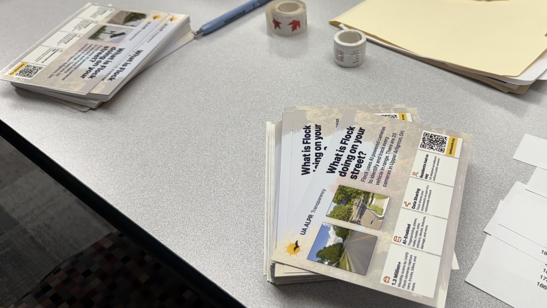 Stacks of informational postcards titled 'What is Flock doing on your street?' by DeFlock Upper Arlington.